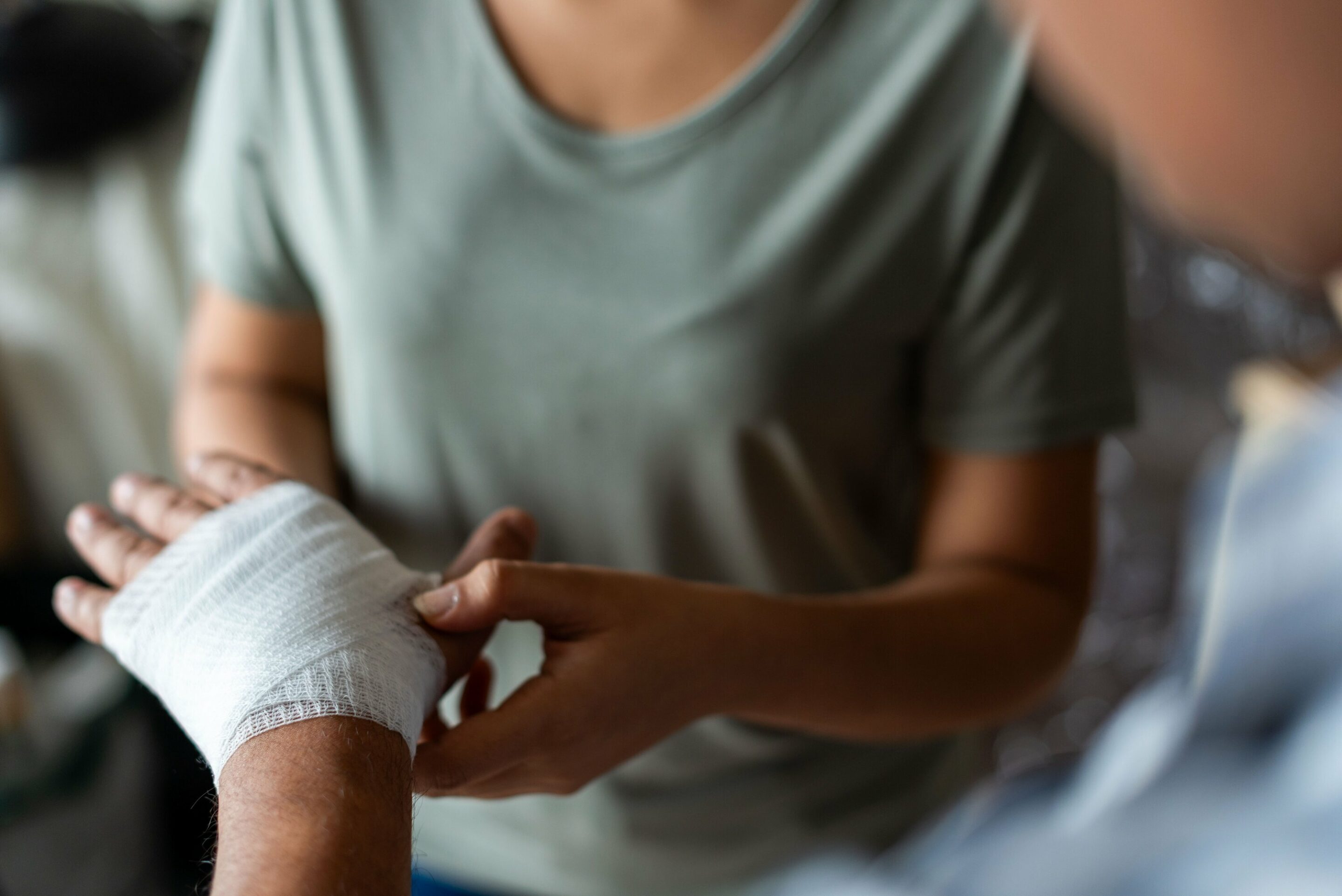 Close-up,Of,A,Person,Bandaging,Another’s,Hand.,The,Focus,Is